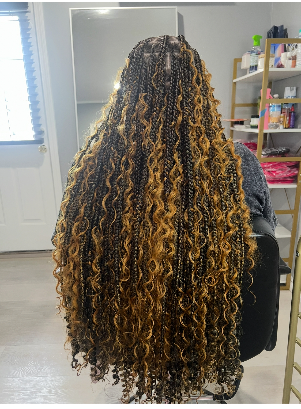 Very long mixed dark and golden-brown box braids with curly ends