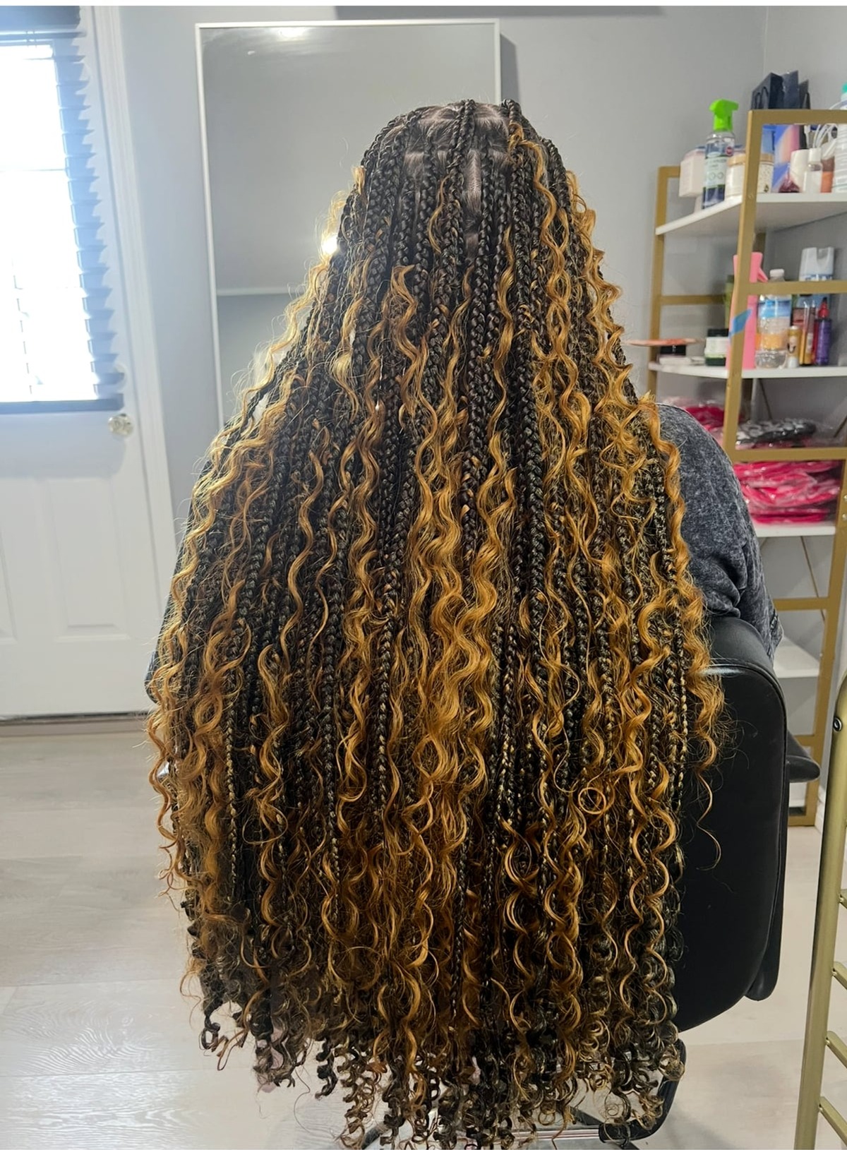 Very long mixed dark and golden-brown box braids with curly ends