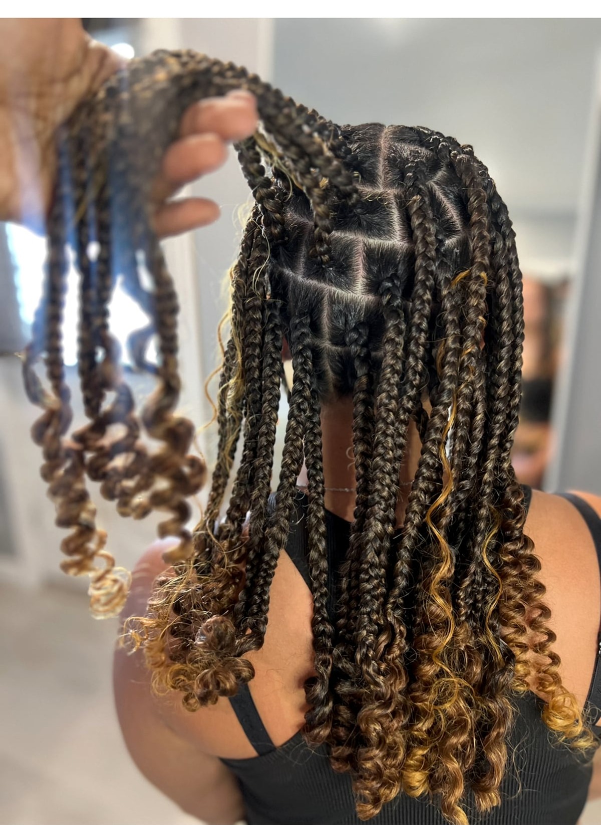 Mixed dark and golden-brown box braids with curly ends, close-up