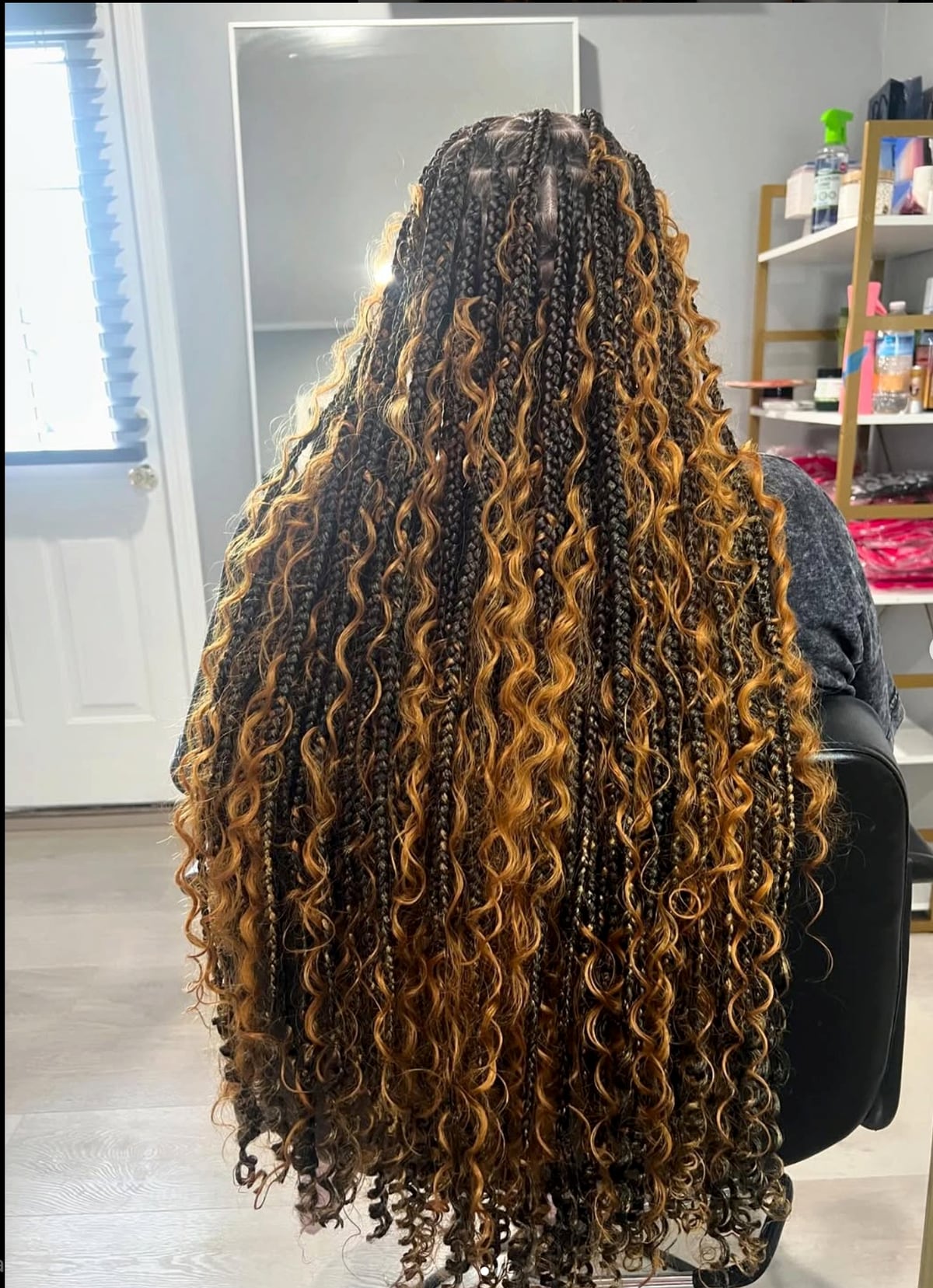 Full-length view of long dark and blonde mixed braids with curly ends