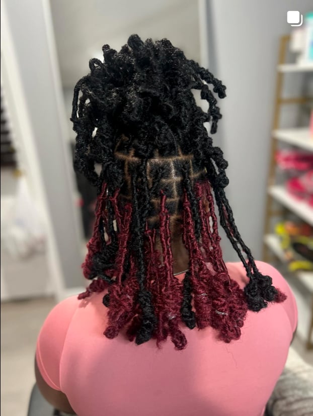 Close-up of black and red mixed locs/braids with curly ends