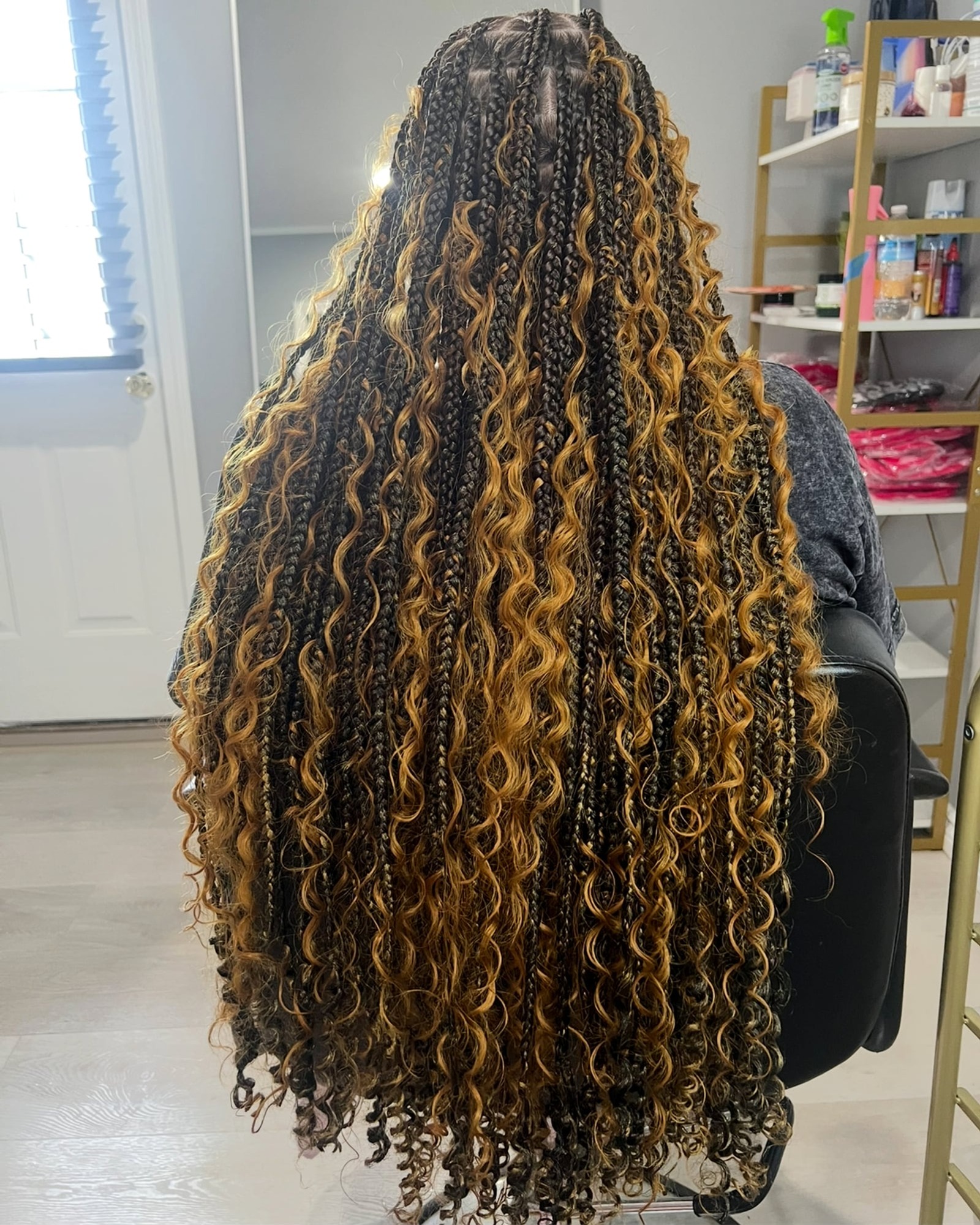 Very long mixed dark and golden-brown box braids with curly ends