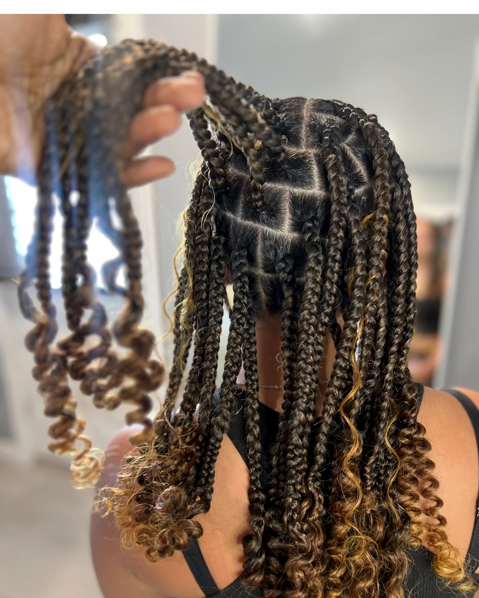 Mixed dark and golden-brown box braids with curly ends, close-up
