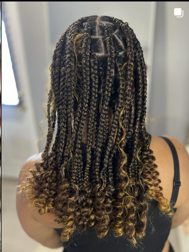 Close-up of dark and blonde mixed braids with curly ends